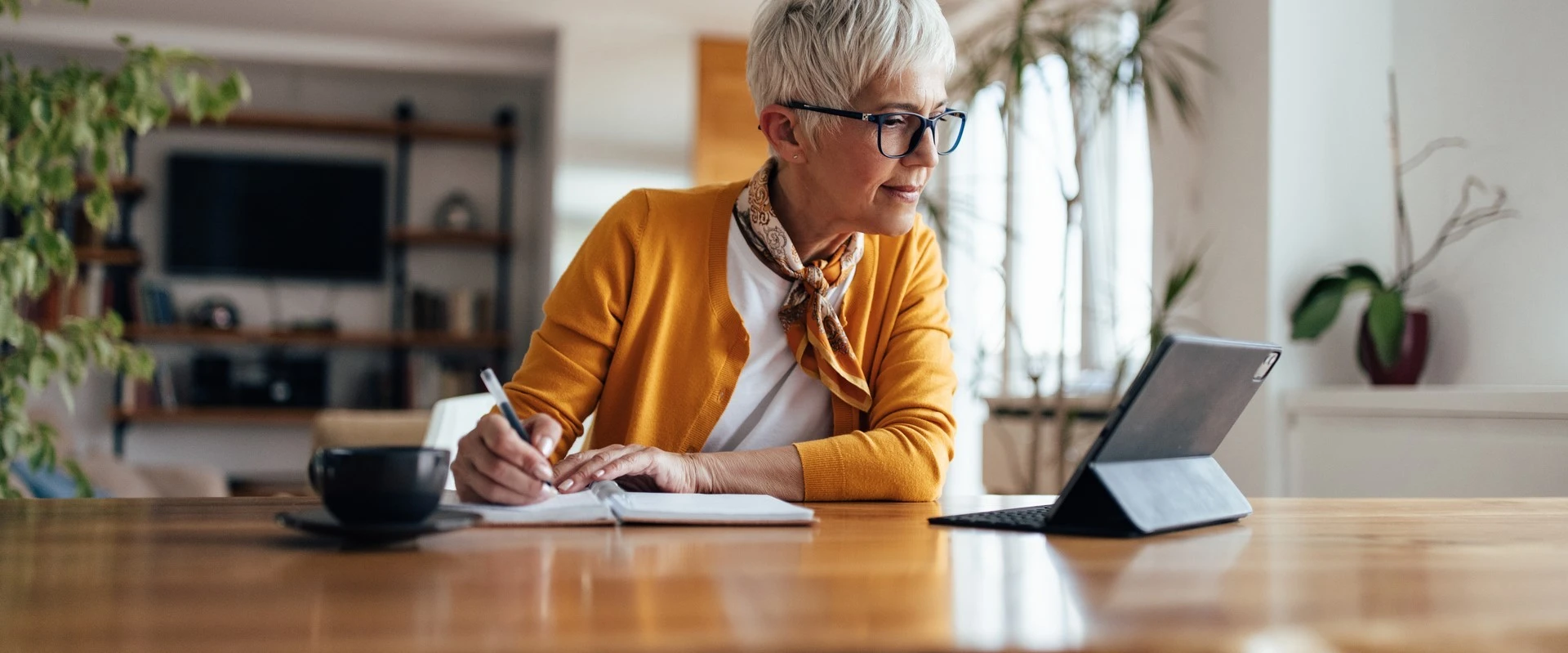 Osoba siedząca przy biurku z tabletem
