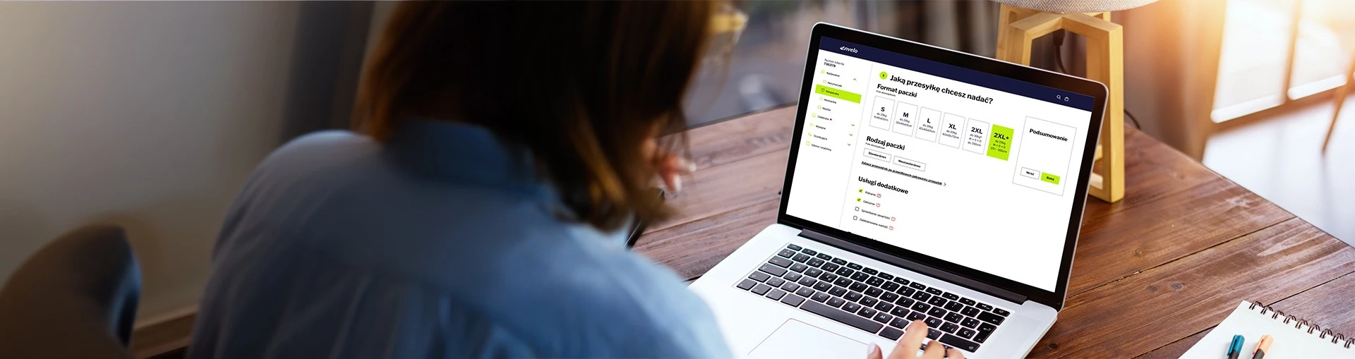 Osoba siedząca tyłem, korzysta z laptopa na którym jest wyświetlona neopaczka